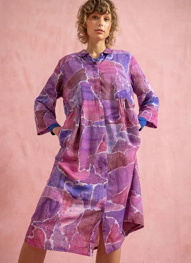 En kvinna klädd i en mönstrad lila klänning från Gudrun Sjödén.