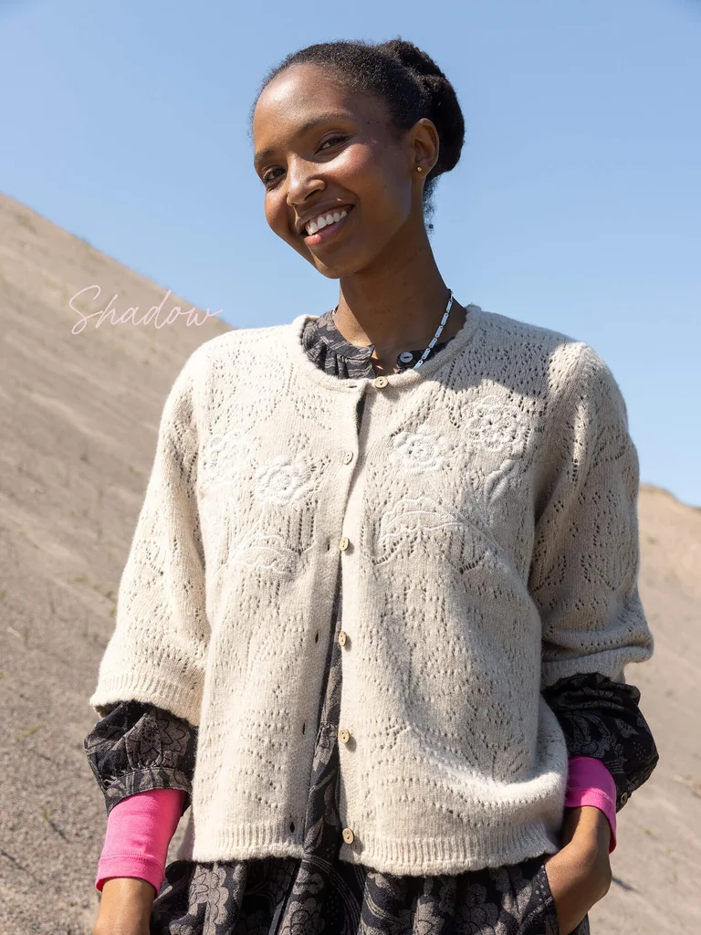 A woman wearing a knit embroidered cardigan from Gudrun Sjödén. 