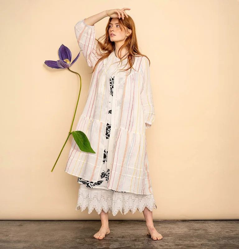 A woman wearing a striped linen dress from Gudrun Sjödén. 
