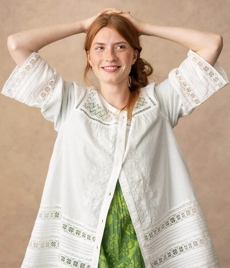 A woman wearing a white blouse from Gudrun Sjödén. 