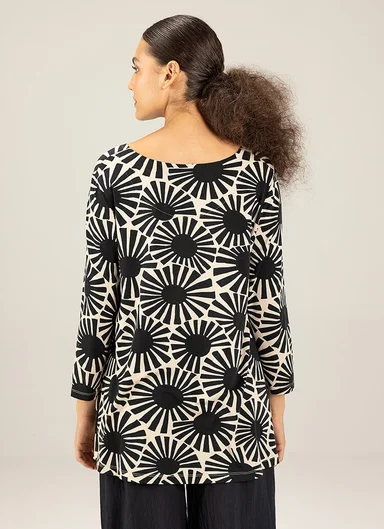 A woman with her back to the camera wearing a top with a graphic pattern from Gudrun Sjödén.