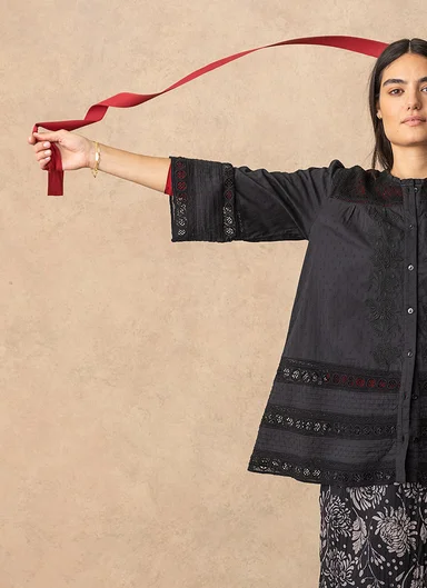 A woman wearing a black blouse from Gudrun Sjödén. 