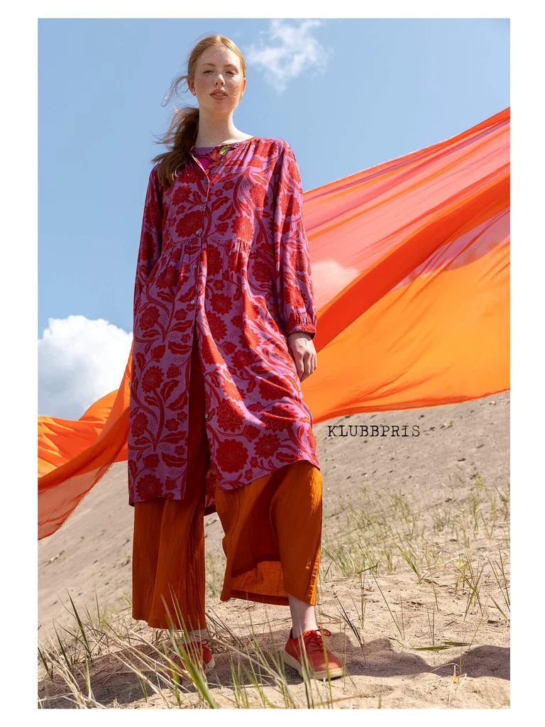 A woman wearing a floral dress from Gudrun Sjödén.  