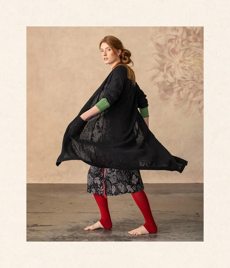 A woman wearing a black cardigan from Gudrun Sjödén. 