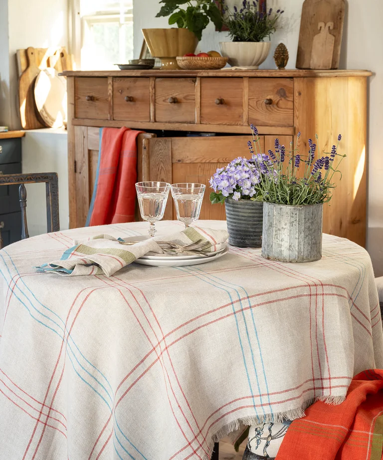 A round table with a natural-colored checked tablecloth in a linen blend from Gudrun Sjödén.
