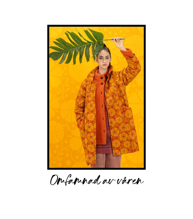 A woman wearing a patterned orange coat from Gudrun Sjödén. 