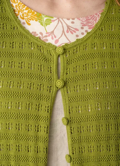 A woman wearing a green knit cardigan from Gudrun Sjödén.  