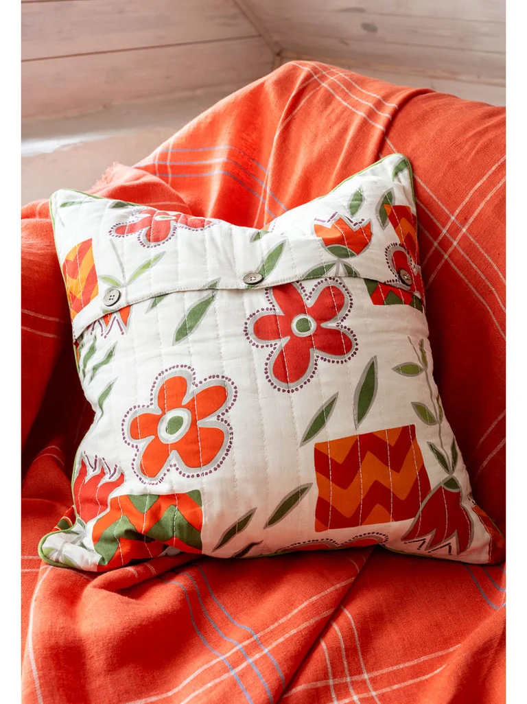 A cushion cover from Gudrun Sjödén with orange and red flowers.