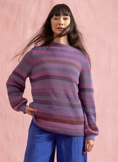 En kvinna klädd i en randig stickad tröja från Gudrun Sjödén. 