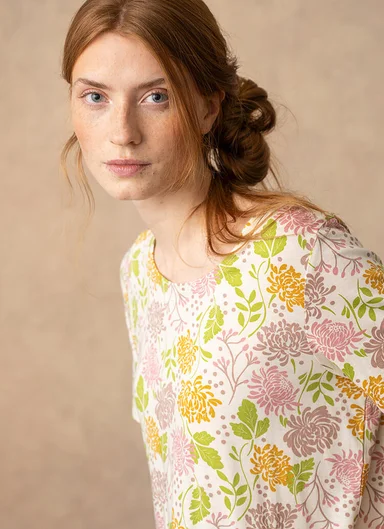 A woman wearing a floral-patterned sweater from Gudrun Sjödén.  