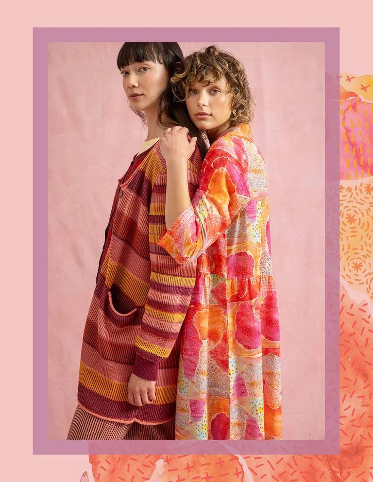 Två kvinnor klädda i orangemönstrade kläder från Gudrun Sjödén.