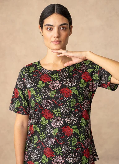 A woman wearing a floral-patterned sweater from Gudrun Sjödén. 