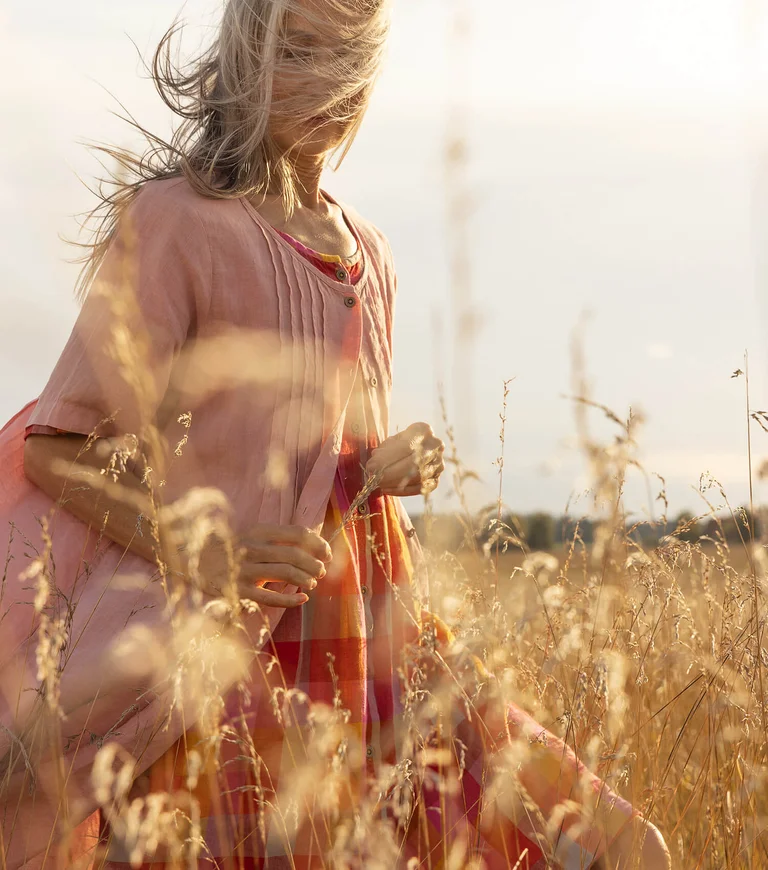 A woman wearing a pink dress from Gudrun Sjödén.