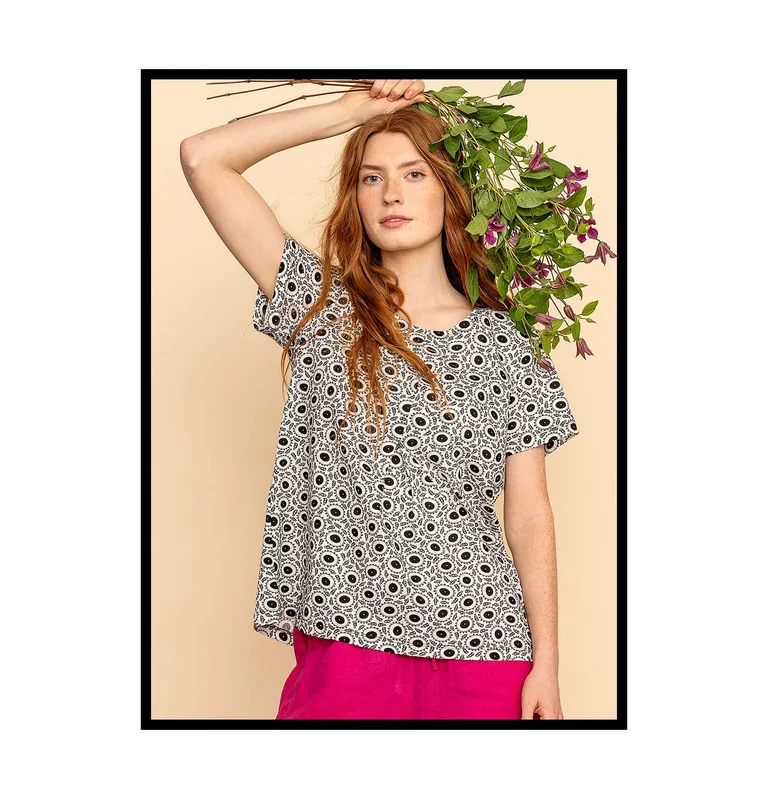 A woman wearing a black and white floral top from Gudrun Sjödén. 