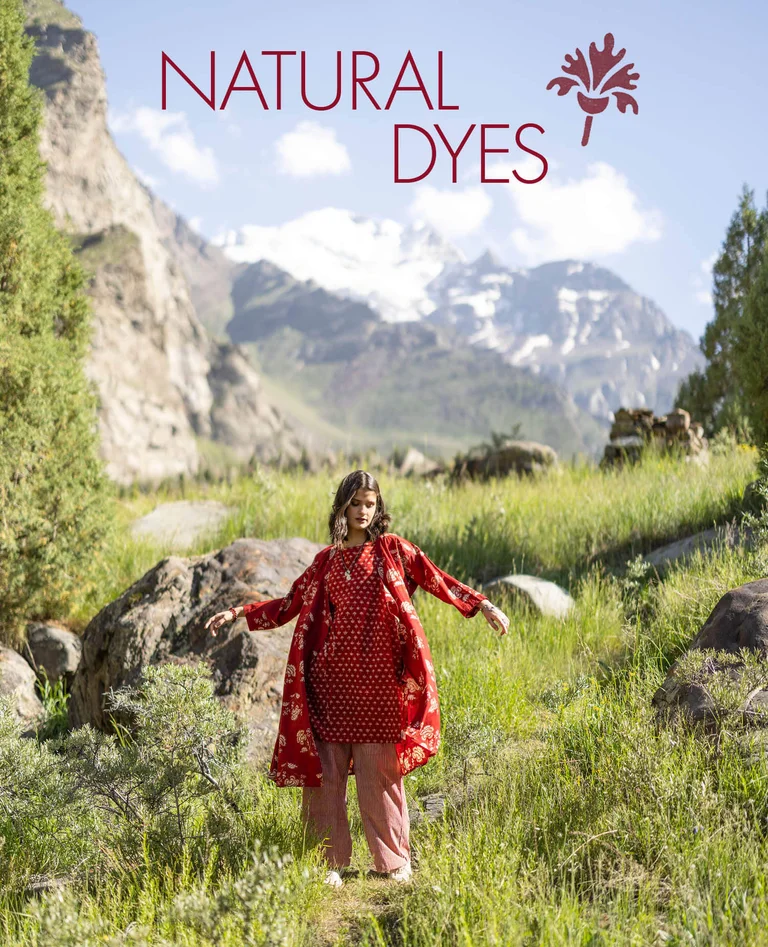 En kvinna klädd i en mönstrad klänning och en uppknäppt omlottklänning från Gudrun Sjödén.  