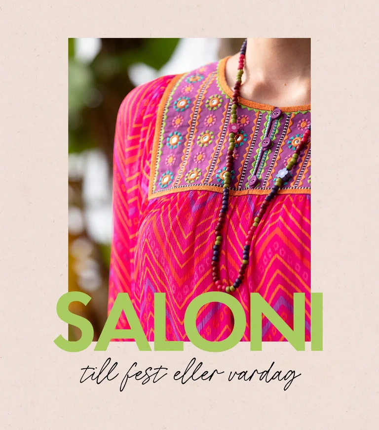 A woman wearing a patterned dress and an open dress from Gudrun Sjödén. 