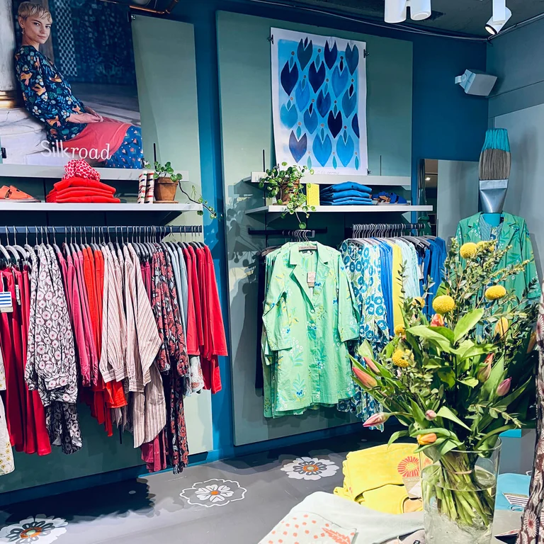 Kvinnor klädda i färgglada kläder från Gudrun Sjödéns butik i Helsingfors. 