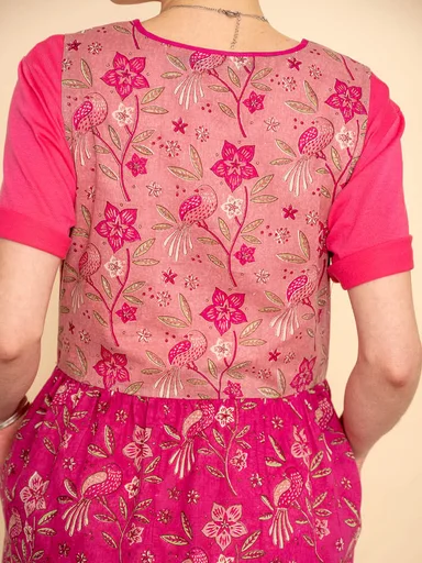 A woman wearing a pink floral dress from Gudrun Sjödén. 